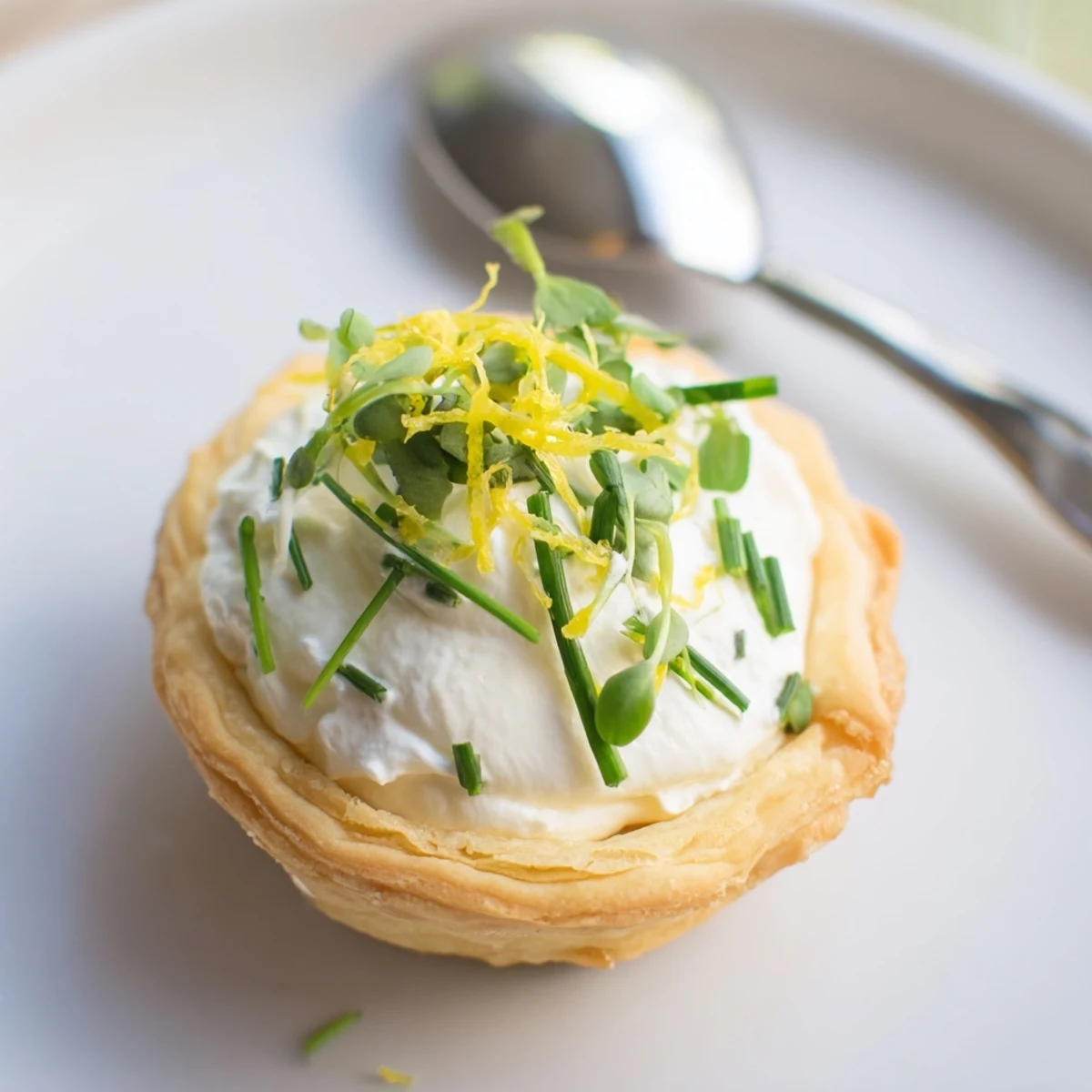 Freshly baked Lemon Appetizer Tartlet with creamy lemon filling, showcased on a wooden board.