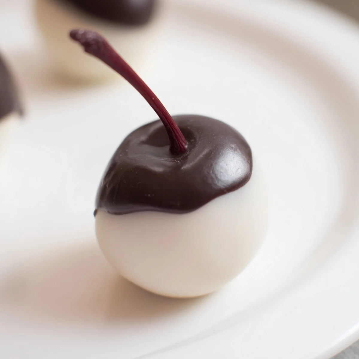 Stemmed chocolate-covered cherries with a sweet fondant center, ready to serve as homemade confectionery gifts.