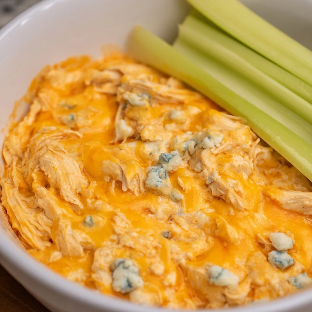 Serving Spicy Buffalo Chicken Dip with celery sticks, perfect for a game day appetizer spread.