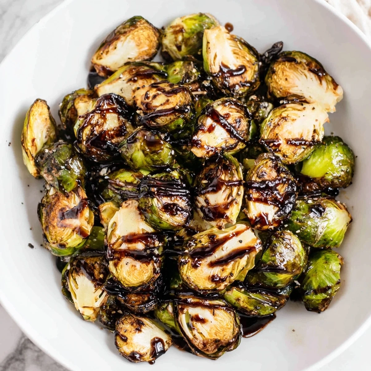 Roasted Brussels Sprouts with Balsamic Glaze on a rustic platter, golden and caramelized with a glossy drizzle.