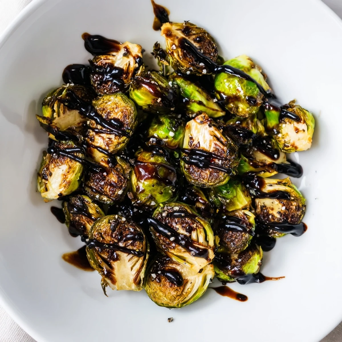Hearty Roasted Brussels Sprouts with Balsamic Glaze plated beside roasted chicken, perfect for a comforting family dinner.