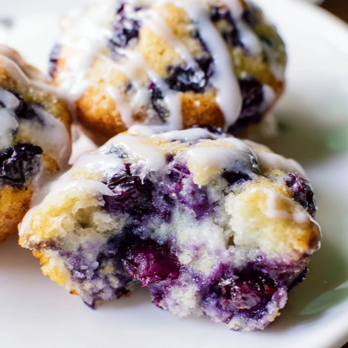 A plate of Lavender Blueberry Tea Cakes served beside a steaming teacup.