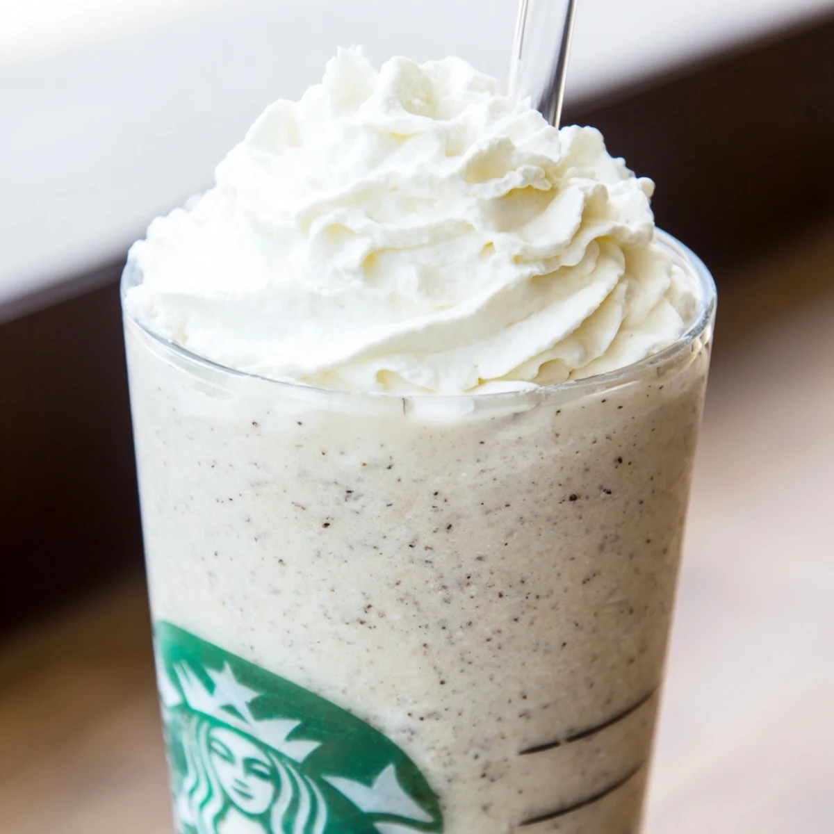 Creamy Starbucks Vanilla Bean Frappuccino topped with whipped cream in a tall glass, a cool homemade treat.