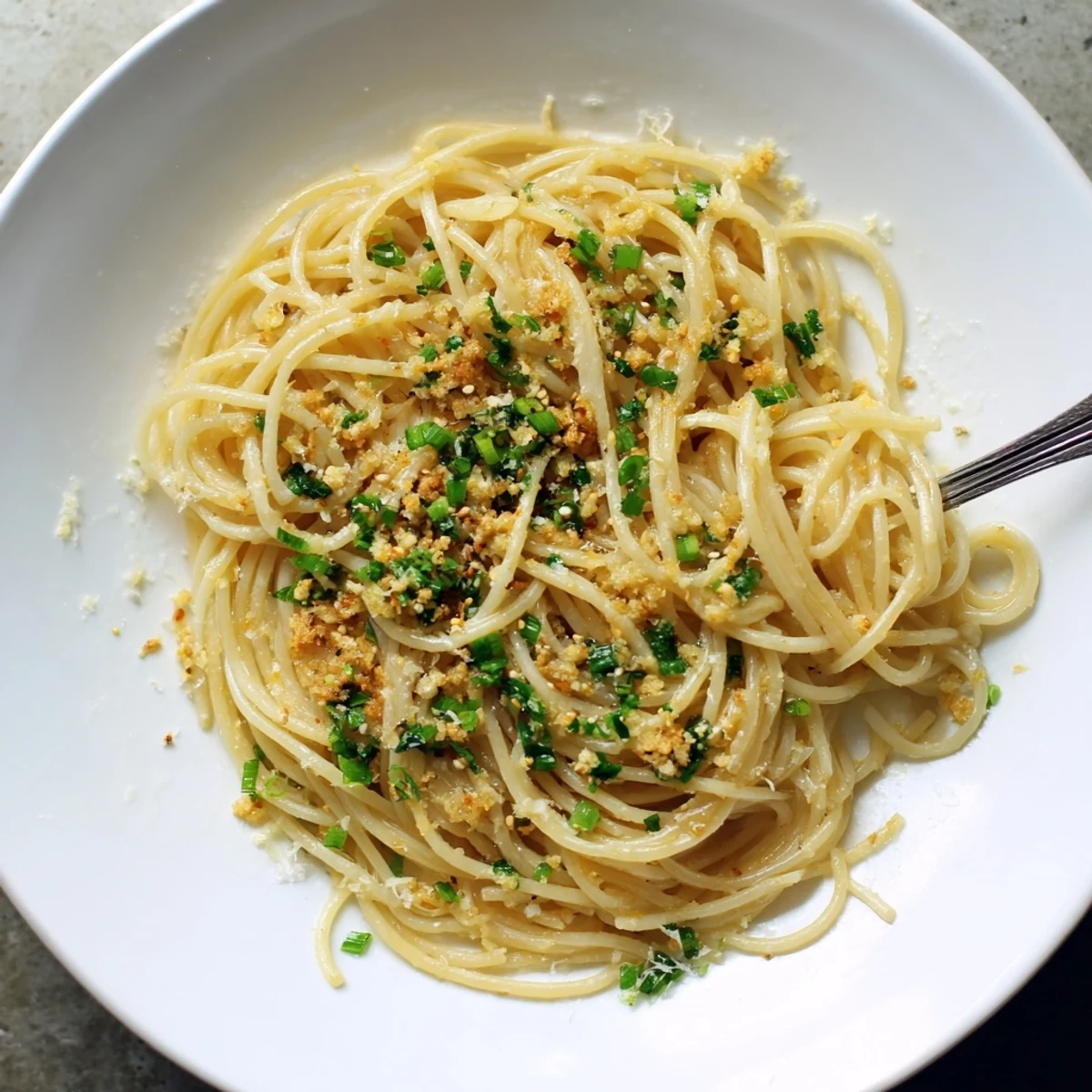 Close-up of Garlic Noodles plated with Parmesan and sesame seeds, highlighting the savory garlicky texture.