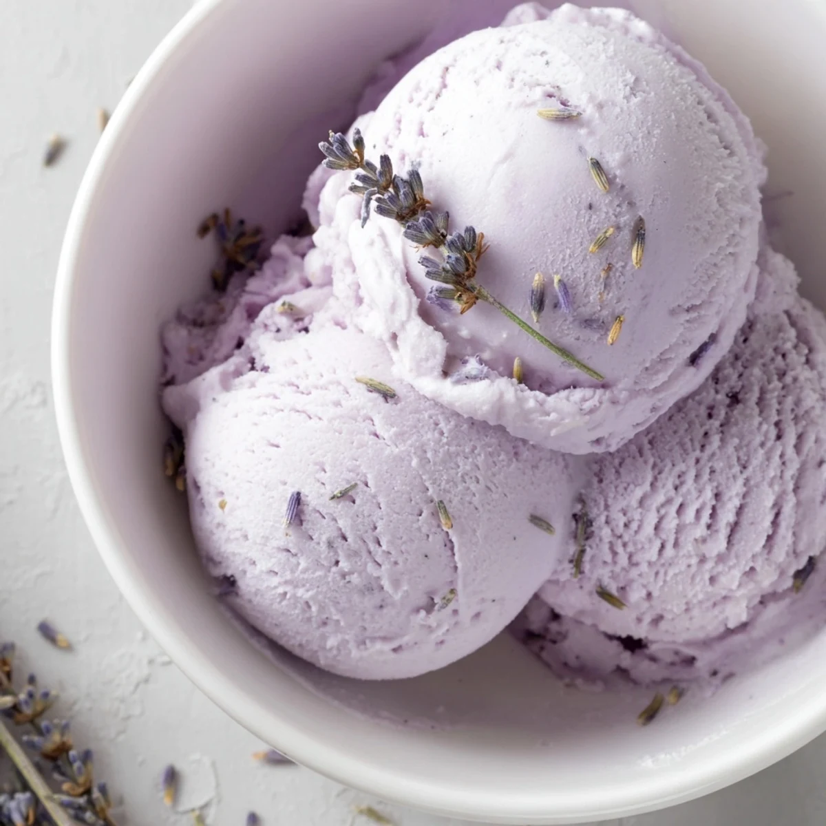Creamy lavender ice cream in a waffle cone on a sunny summer picnic table.