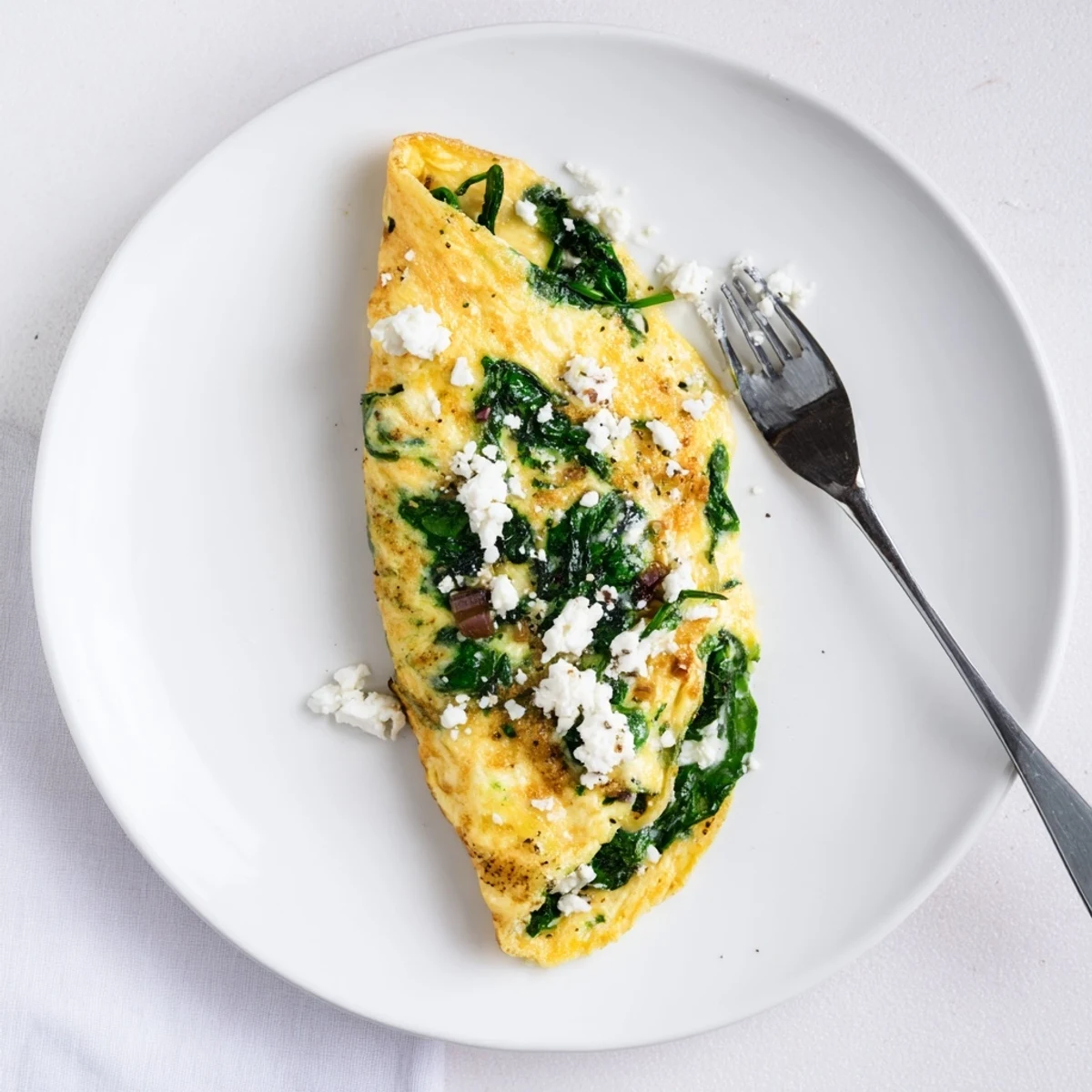 Steaming 15-Minute Spinach and Feta Omelet served alongside whole-grain toast on a wooden breakfast table.
