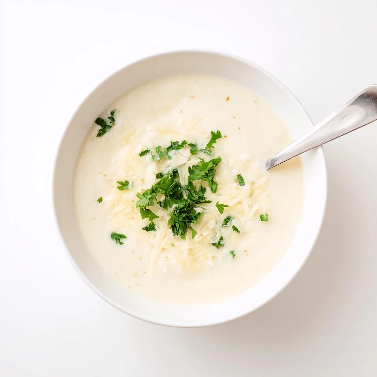 Golden roasted cauliflower and garlic simmer in a pot, ready for blending with Asiago cheese to create this creamy Asiago Roasted Garlic Cauliflower Soup.