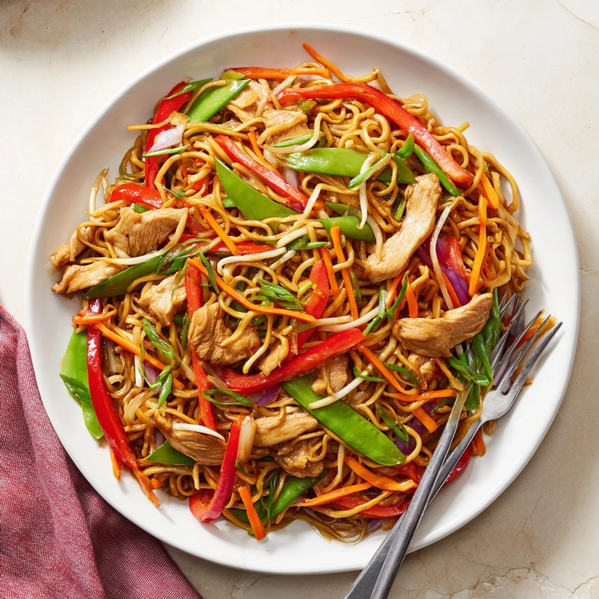 Savory Chicken Chow Mein with bean sprouts and scallions served steaming in bowl.