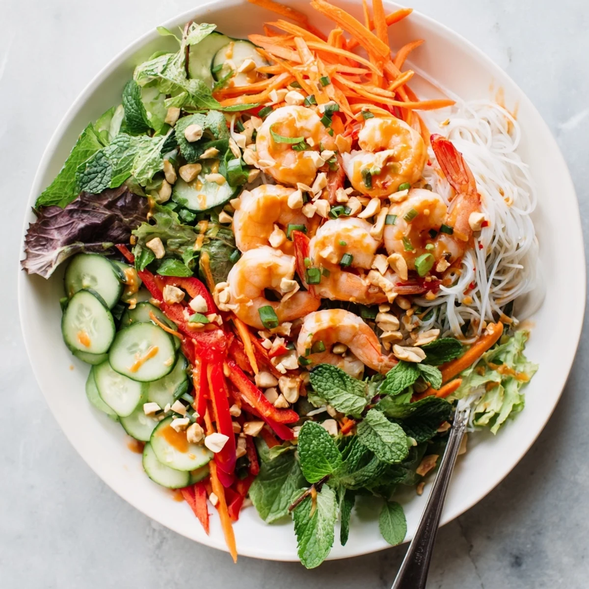 Colorful Spring Roll Salad with crisp vegetables, succulent shrimp, and zesty spicy ginger dressing drizzled over fresh herbs