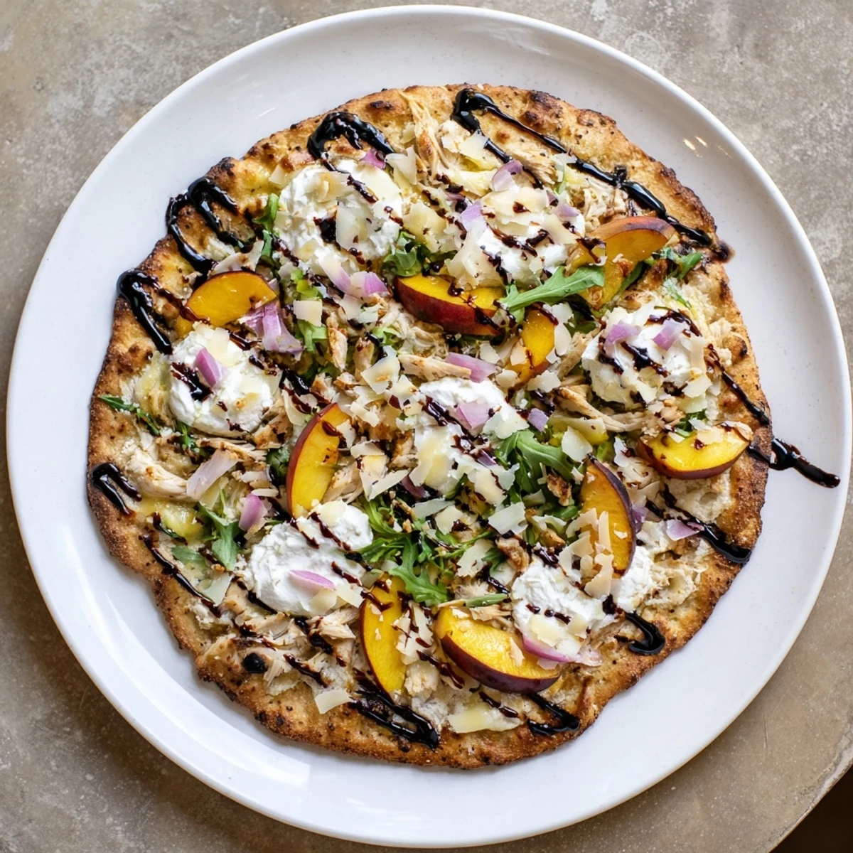 Slice of chicken peach ricotta pizza garnished with arugula and sweet balsamic glaze