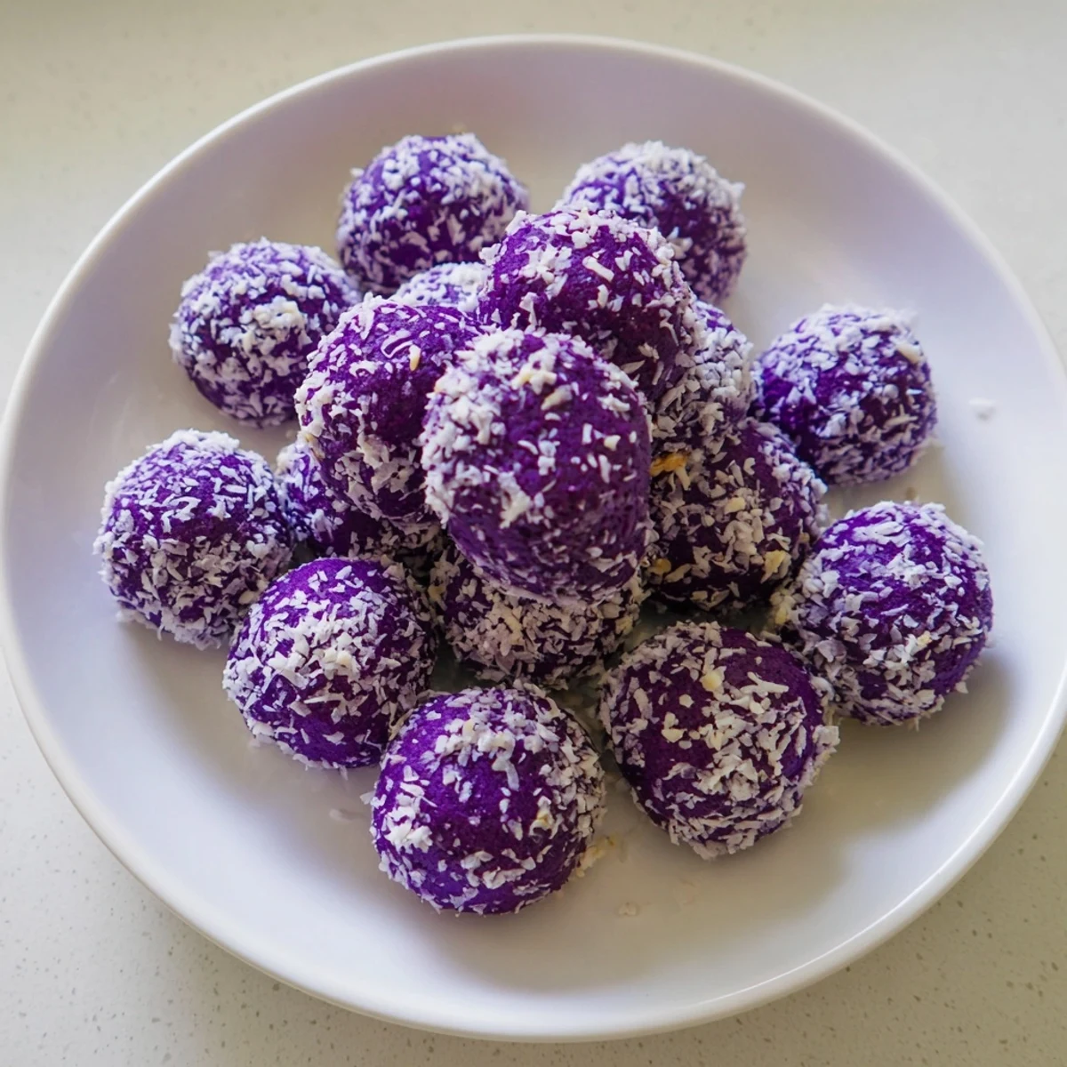 Tender Filipino-Latin fusion cookies rolled in desiccated coconut, freshly baked with soft purple ube centers visible