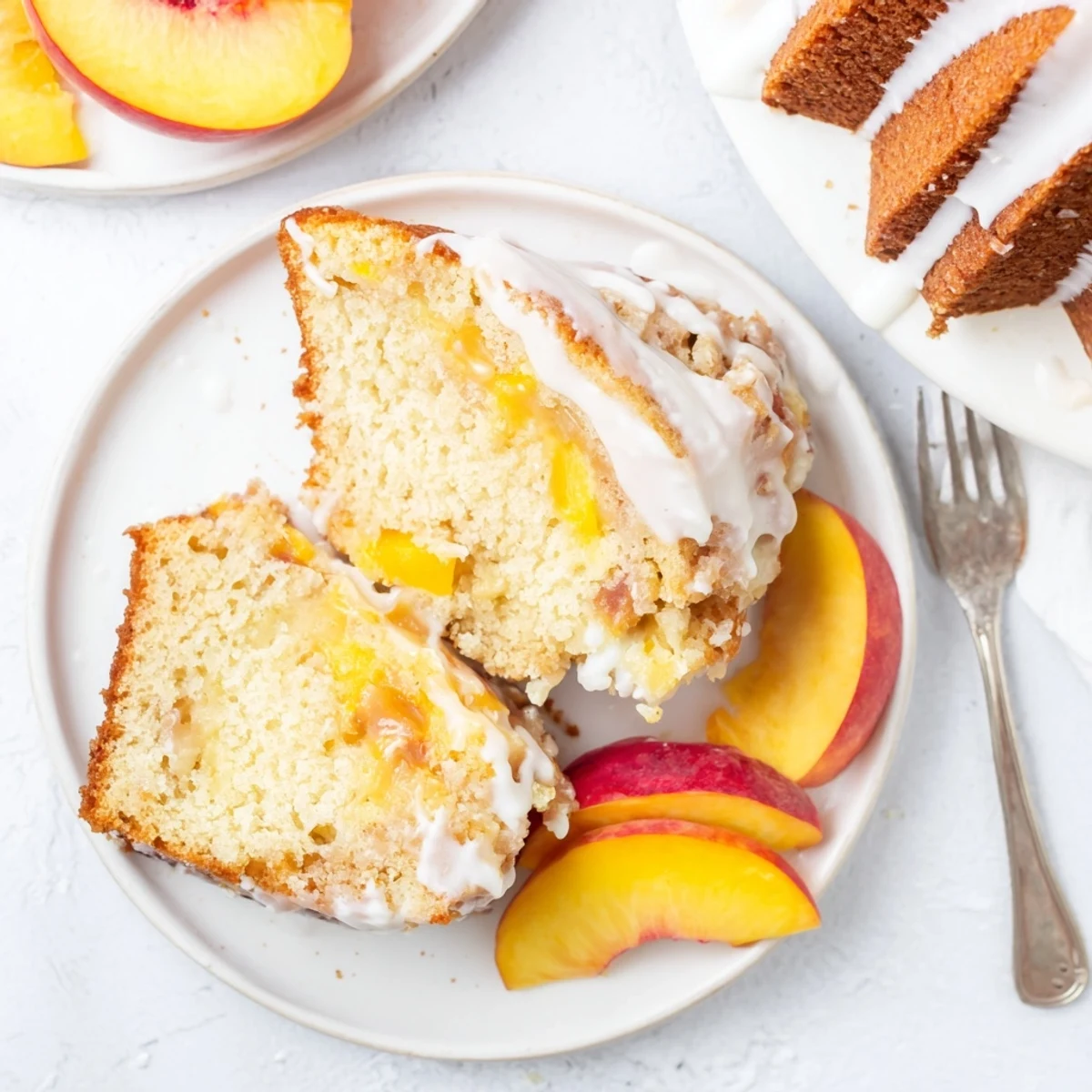 Golden slice of peach cobbler pound cake topped with sweet vanilla glaze