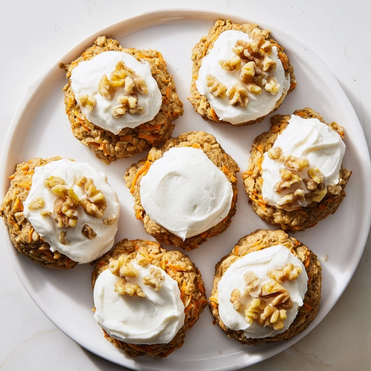 Golden brown spiced carrot cake cookies stacked with fresh grated carrots visible inside
