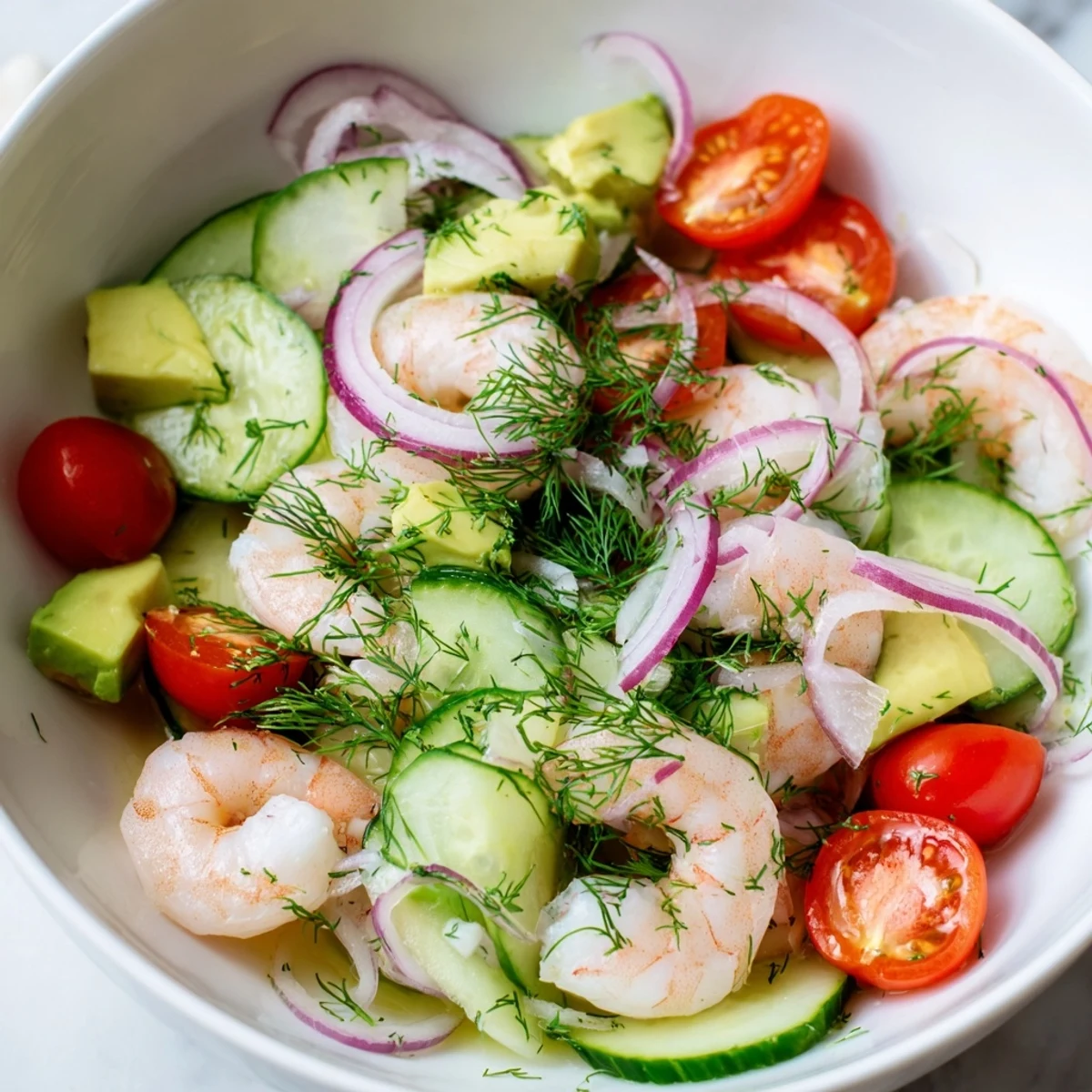 Fresh cucumber shrimp salad featuring tender pink shrimp, crisp cucumber slices, and ripe avocado chunks in a zesty lemon-herb dressing