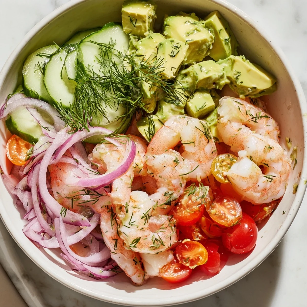 Elegant cucumber shrimp salad plated with tender cooked shrimp, creamy avocado, and thinly sliced vegetables drizzled with tangy lemon dressing