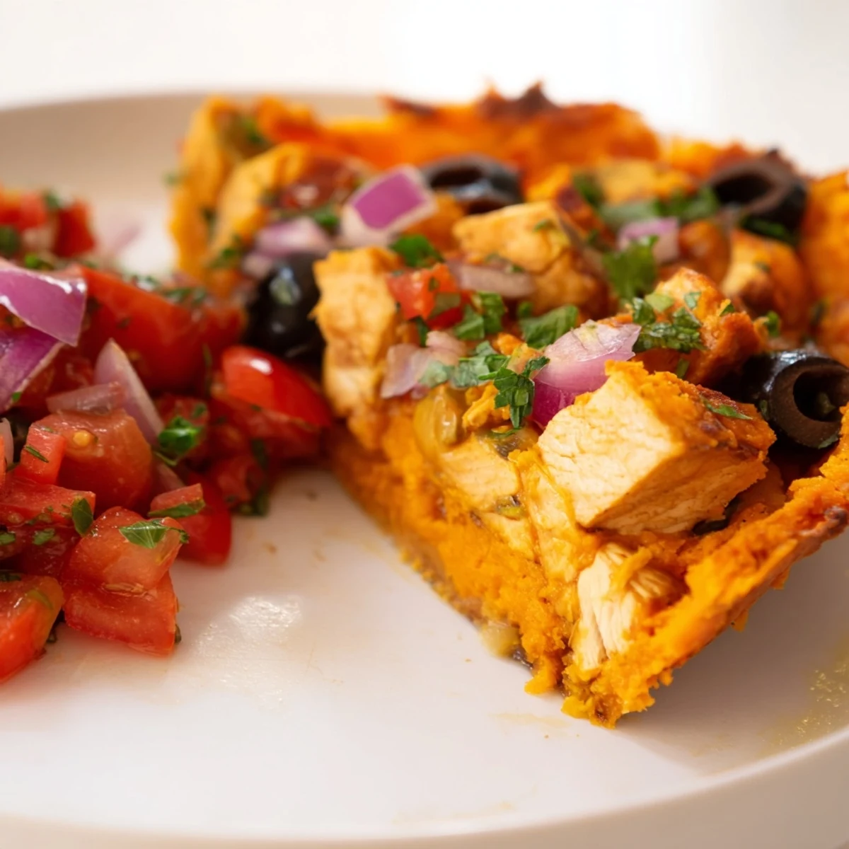 Golden brown sweet potato and chicken pie with zesty tomato olive salsa topping