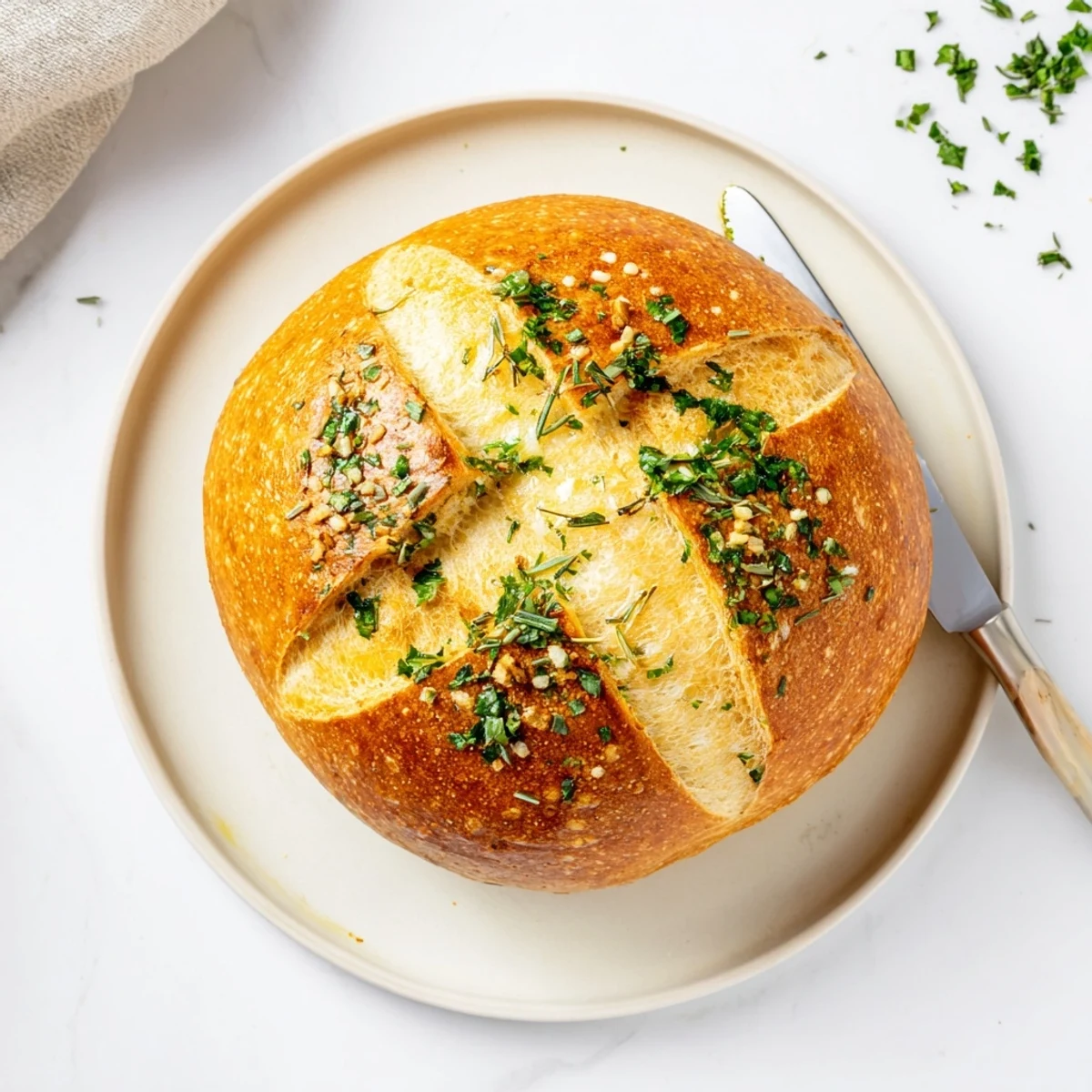 Golden brown garlic herb Dutch oven bread with a crackly crust and soft interior