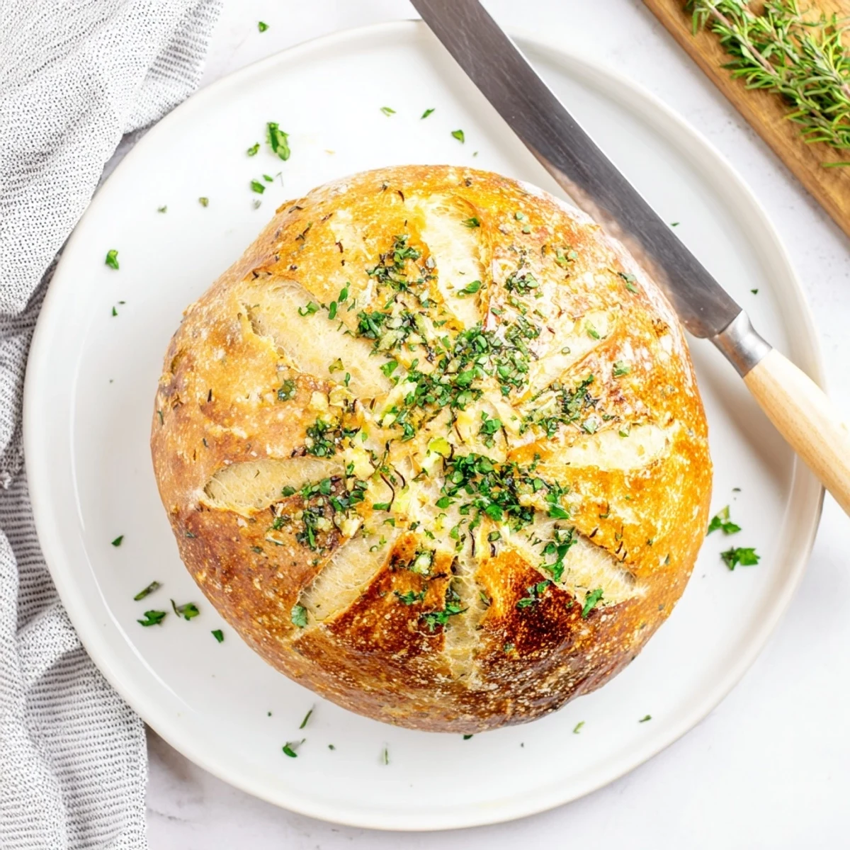 Sliced garlic herb Dutch oven bread brushed with melted butter and sprinkled with parsley