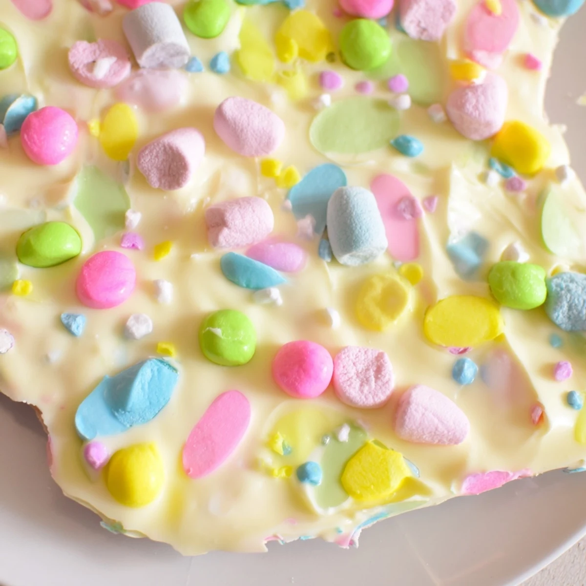 Creamy white chocolate Easter marshmallow bark topped with pastel candy eggs and colorful sprinkles