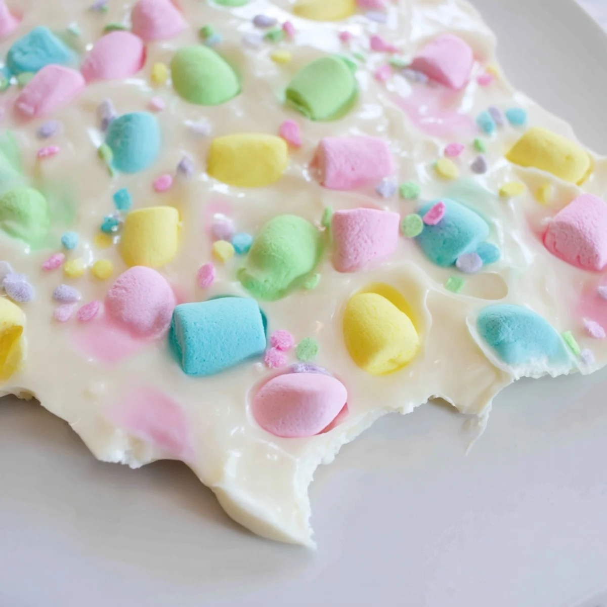 Sweet Easter marshmallow bark broken into pieces revealing pastel sprinkles and candy-coated egg decorations