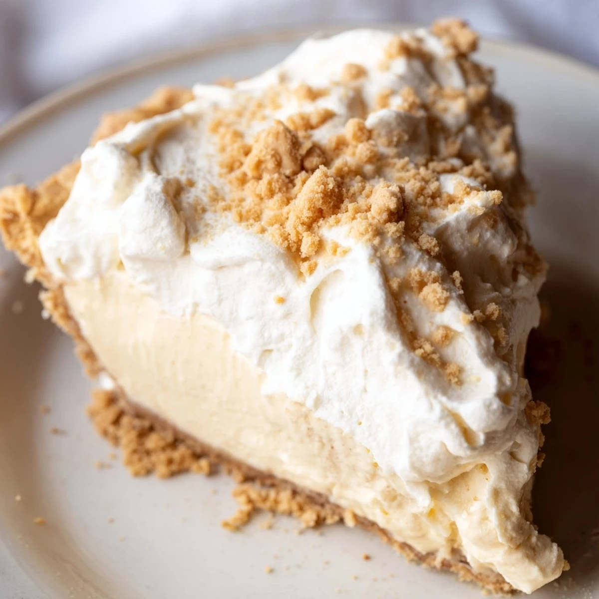 Creamy Amish peanut butter dream pie topped with fluffy whipped cream and golden crumbs