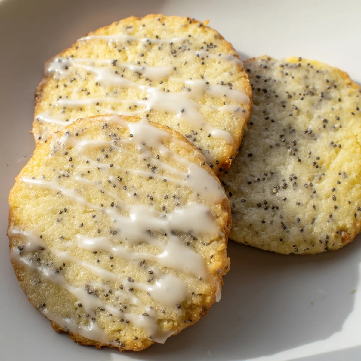Lemon Poppy Seed Cookies with golden edges arranged on a rustic white ceramic plate