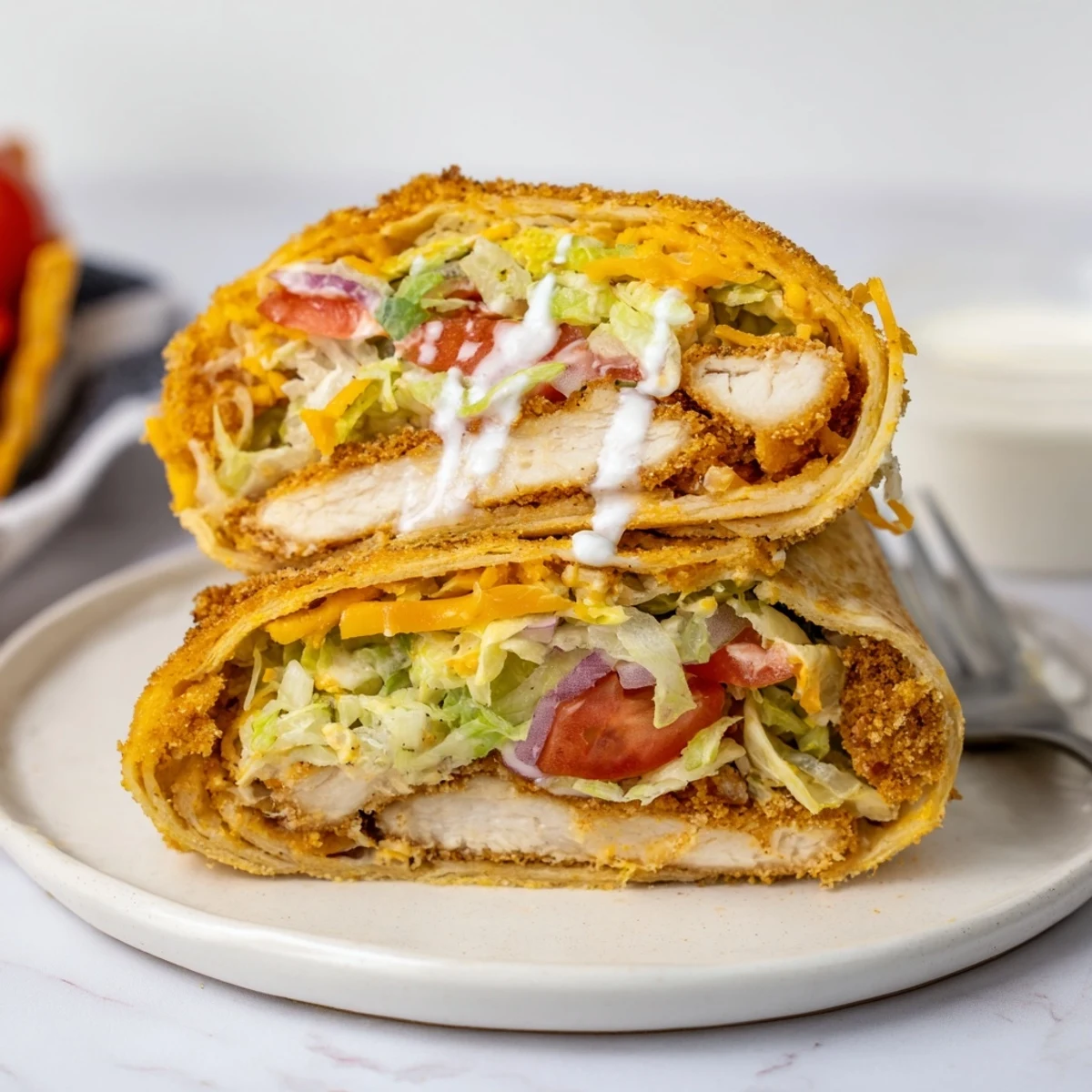 Golden tenders and cheddar spill from a Crispy Chicken Ranch Wrap.