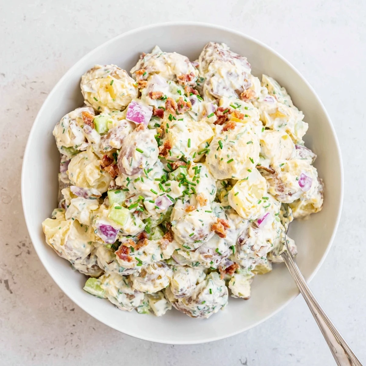 Steakhouse Potato Salad served alongside grilled steak, smoky dressing and herbs