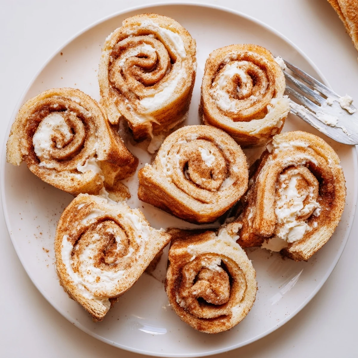 Cinnamon Roll French Toast Roll Ups brunch bites, buttery exterior sprinkled with powdered sugar