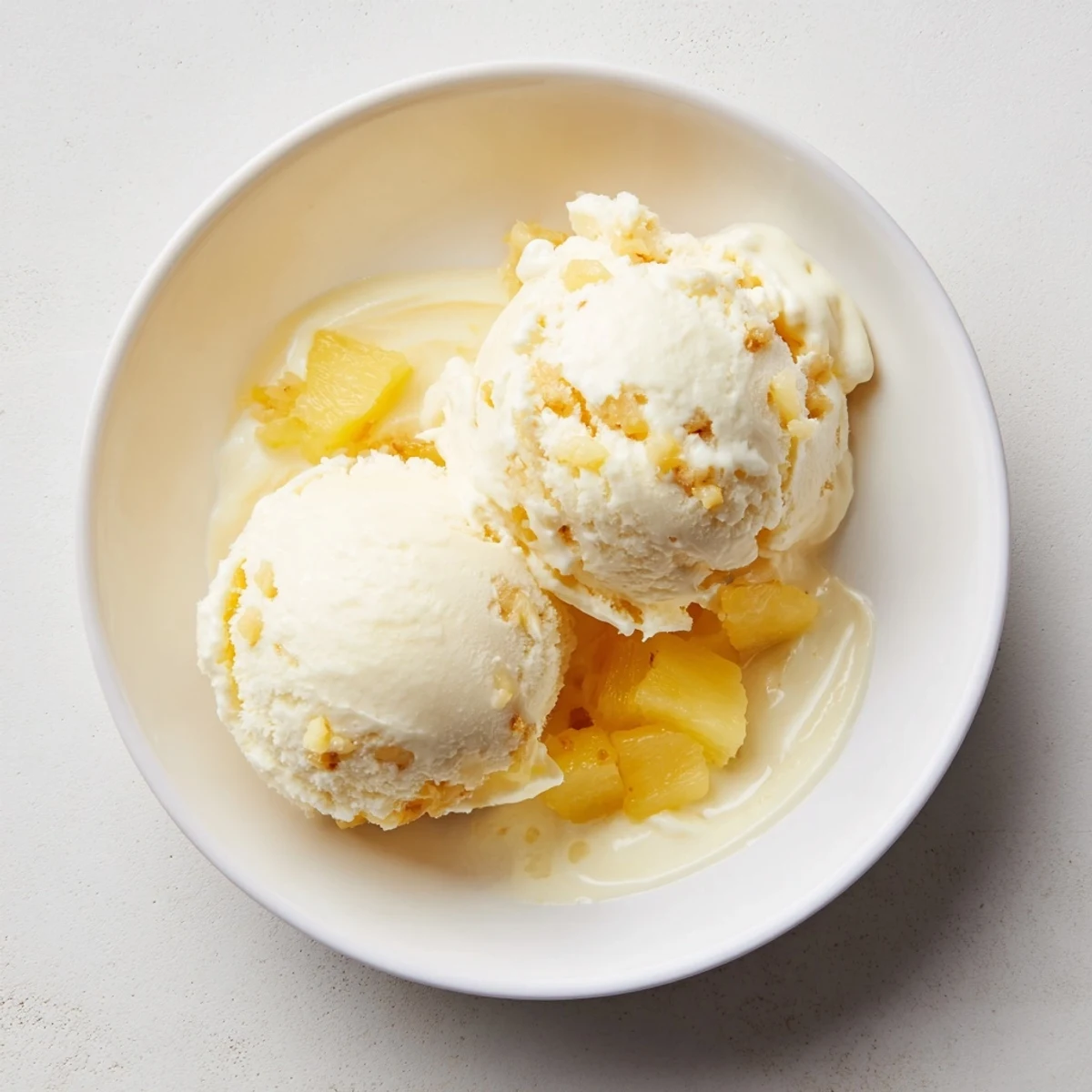 Creamy Pineapple Ice Cream scoops glistening, silky texture with bright pineapple aroma