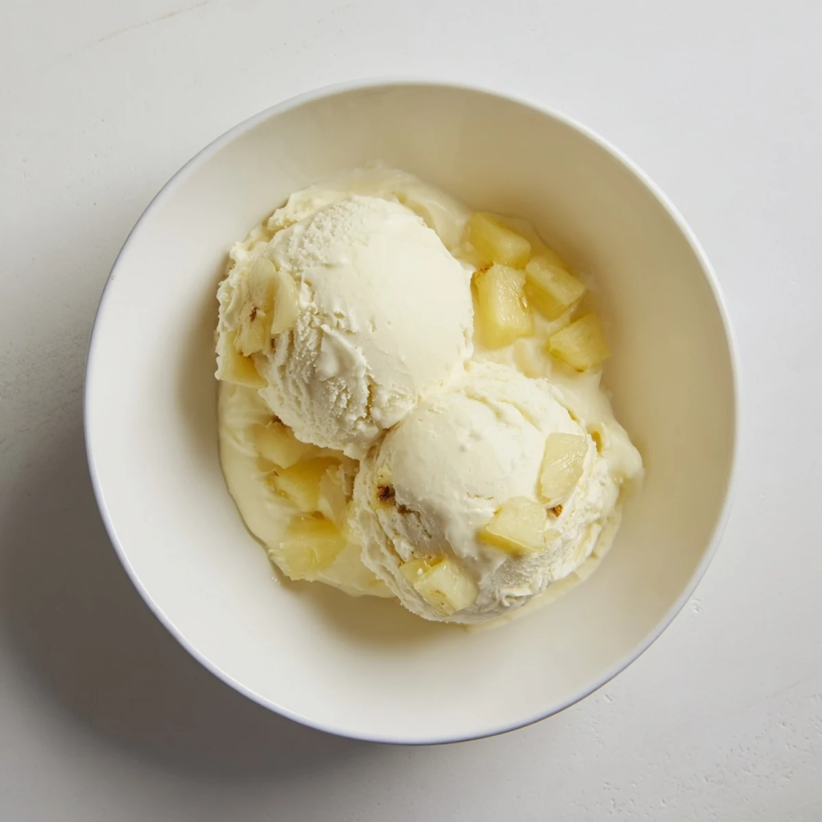 Chilled Creamy Pineapple Ice Cream on spoon, tangy sweet, perfect summer dessert