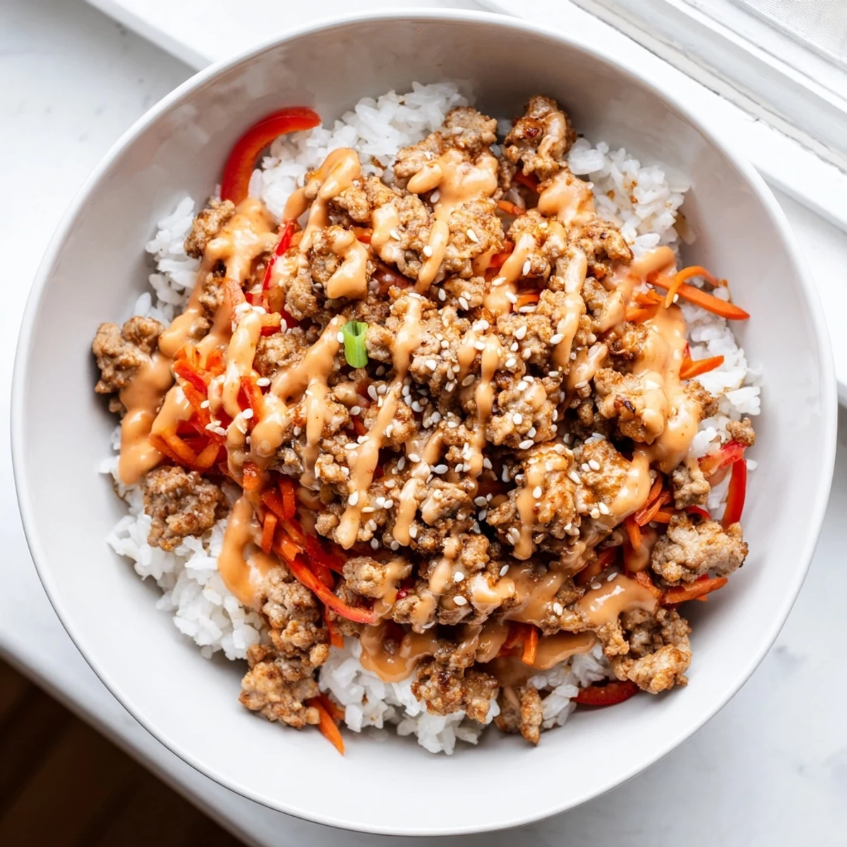 Seasoned ground turkey rice bowls topped with crisp veggies and spicy sriracha mayo drizzle