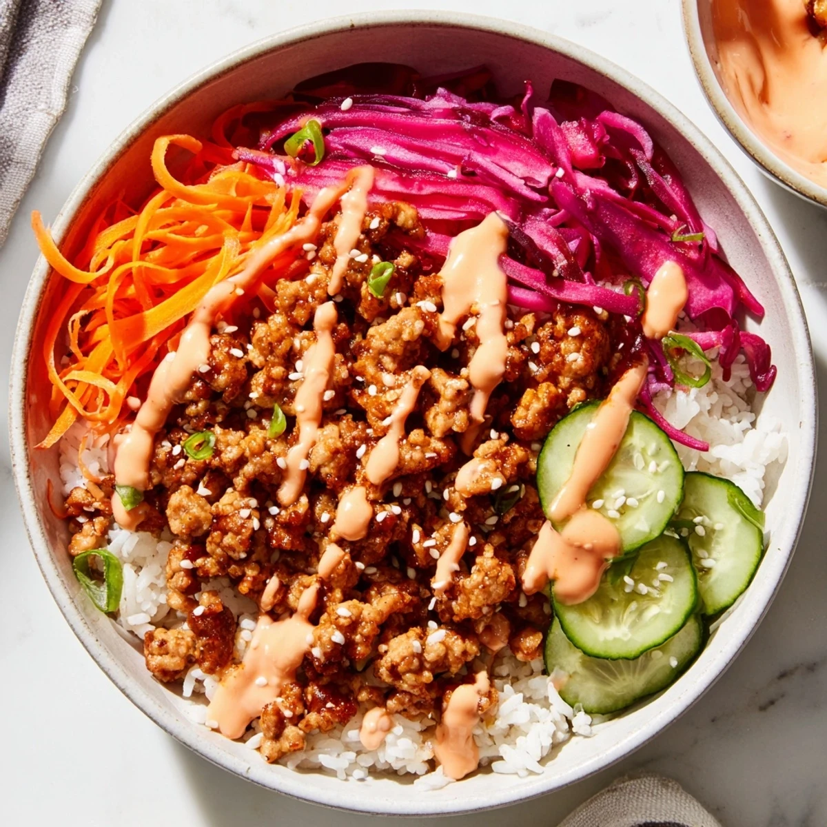 Hearty bowl of seasoned ground turkey over fluffy rice with creamy spicy sauce