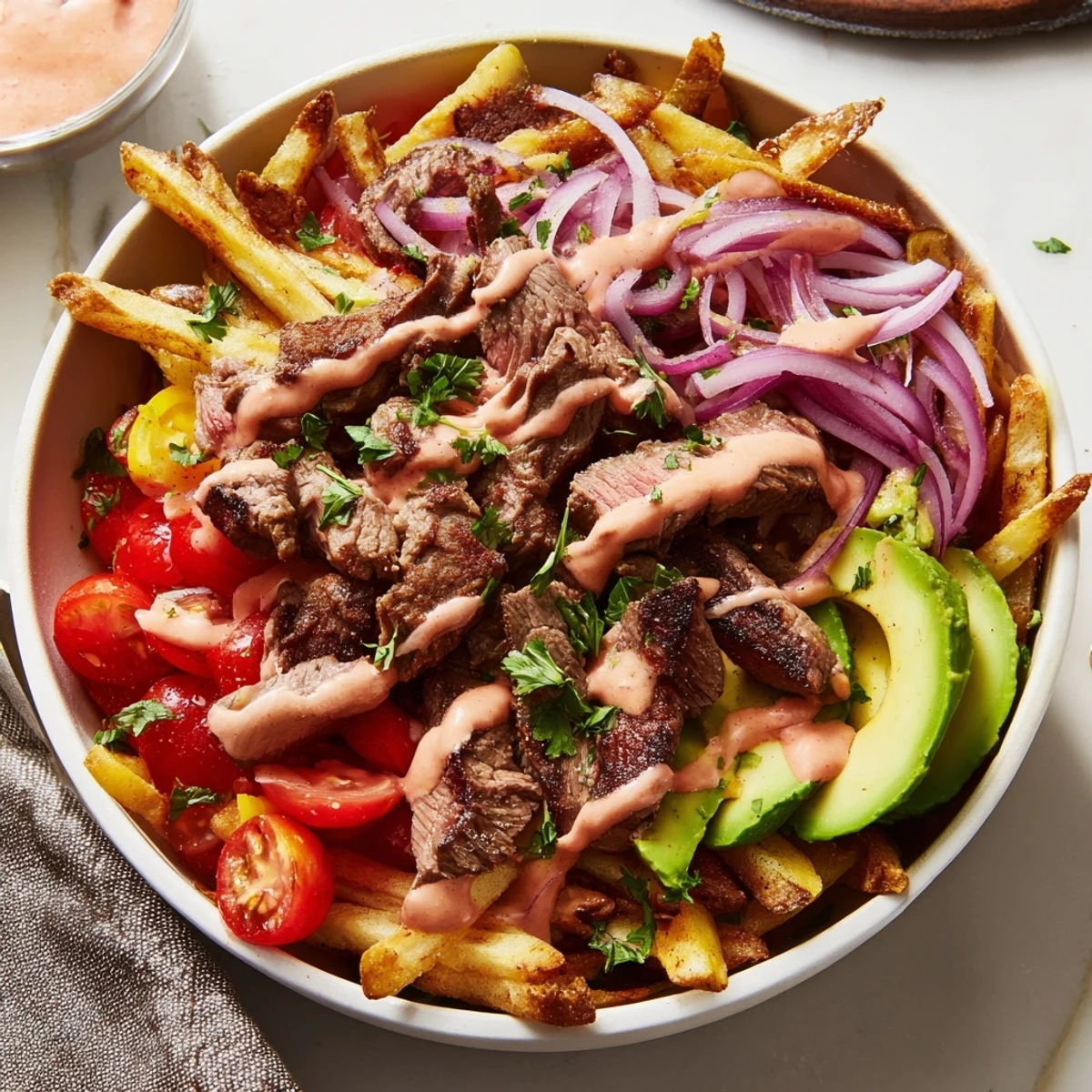 Crusty seared steak strips with golden crispy fries in a hearty bowl