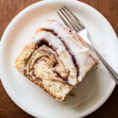 Buttery breakfast cake featuring marbled cinnamon swirls and sweet vanilla drizzle on a serving platter