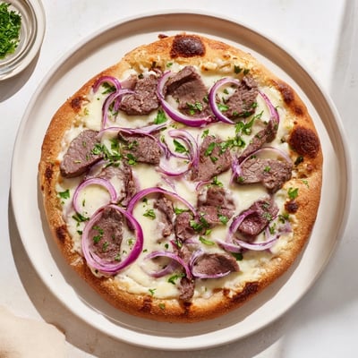 Creamy white sauce Beef Alfredo Pizza topped with tender beef strips and melted cheeses